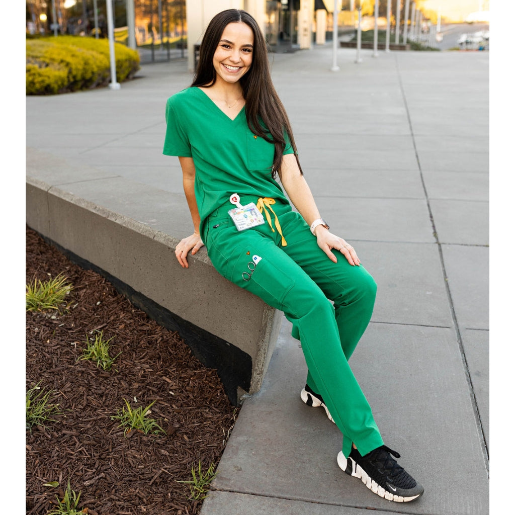 Hunter green scrubs for women, seated photo.