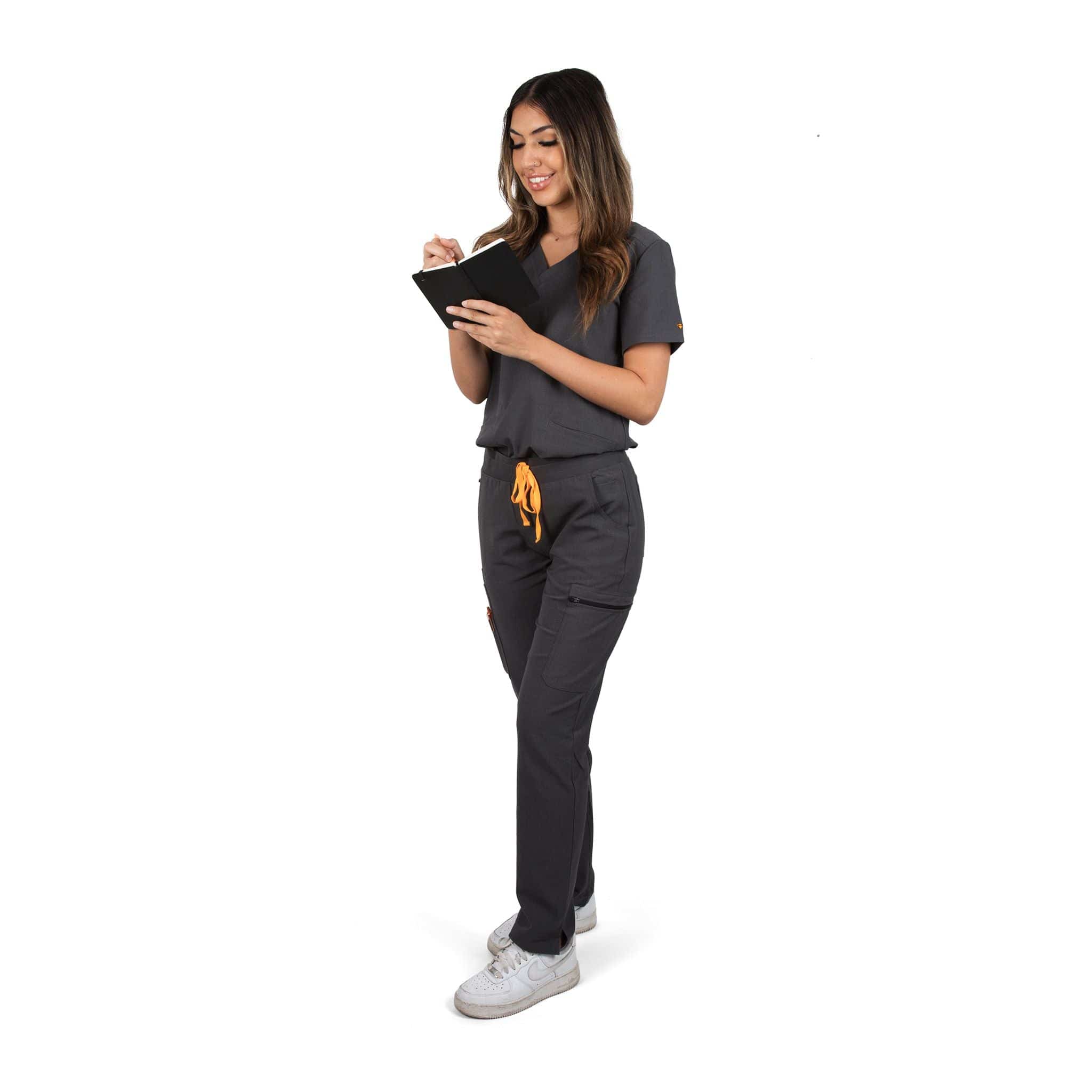 Standing nurse wearing the Pfeiffer scrub pants in charcoal gray.