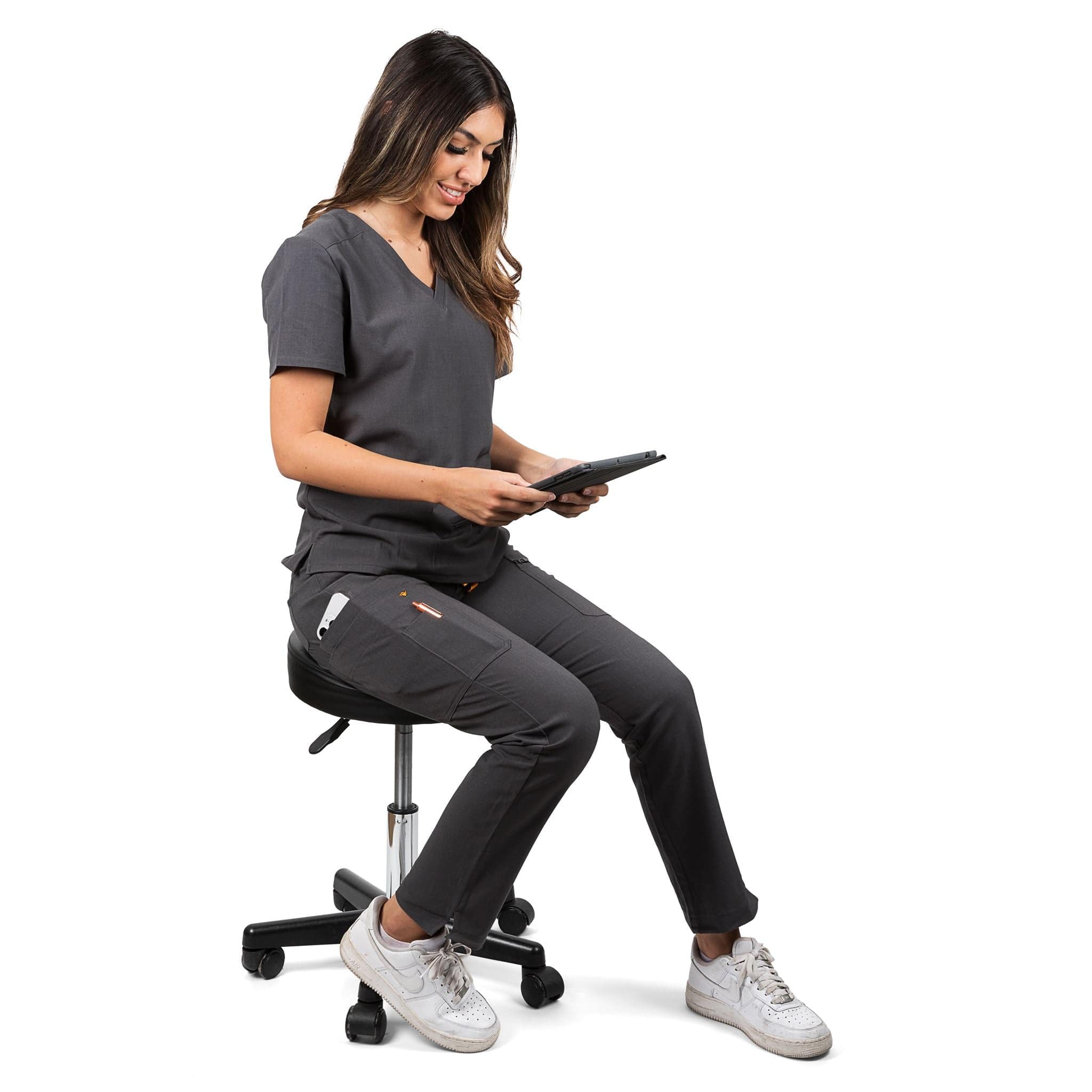 Seated nurse wearing the Pfeiffer scrub pants in charcoal gray.