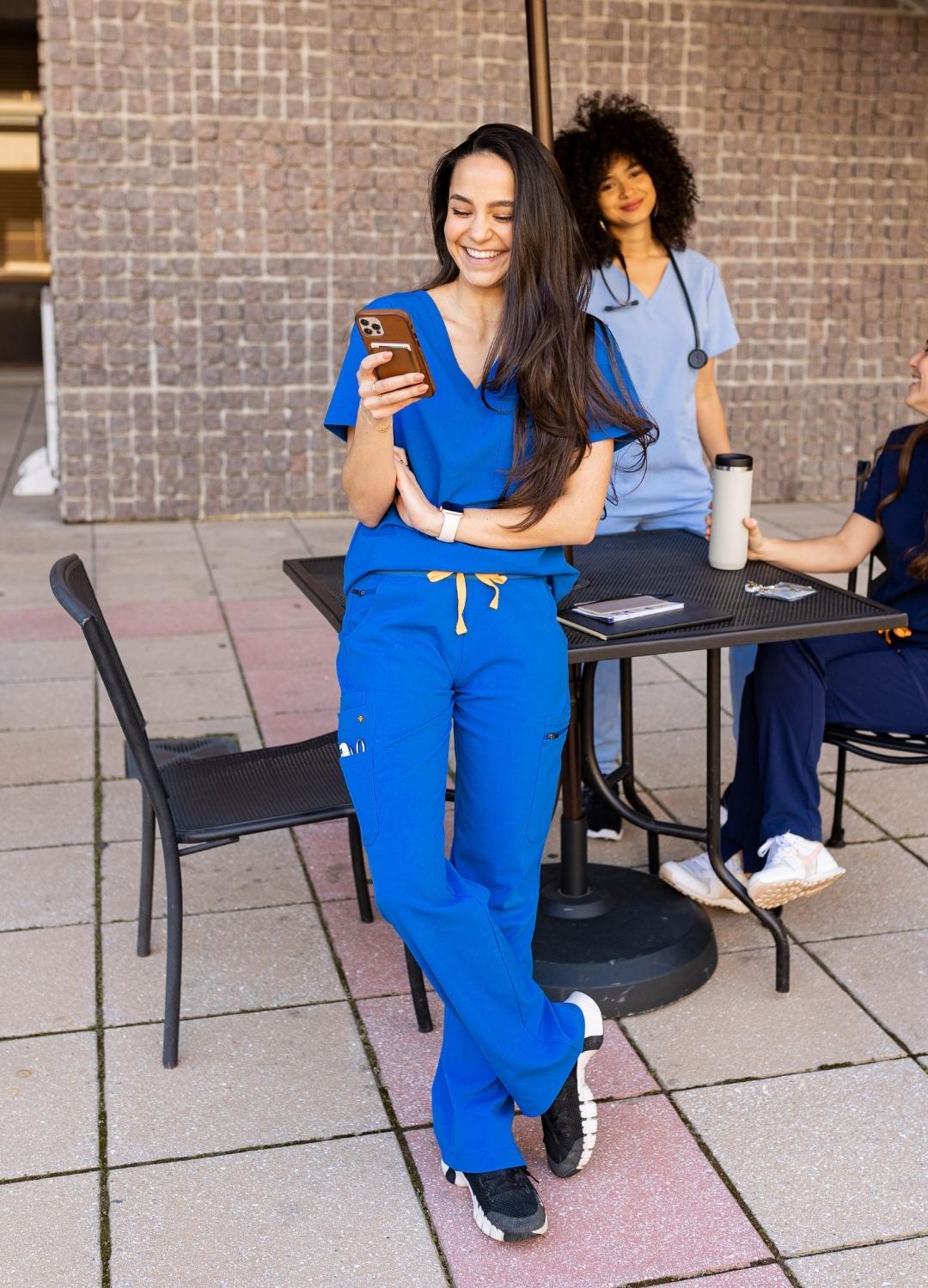 Woman wearing luxury royal blue scrubs on lunch break.