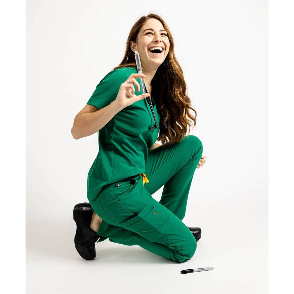 Lower front picture of the the Pfeiffer scrub pants in hunter green kneeling.