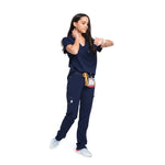 Nurse walking in a full body picture of the the Pfeiffer scrub pants in navy blue.