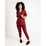 Full body picture of the the Caswell scrub top in burgundy.