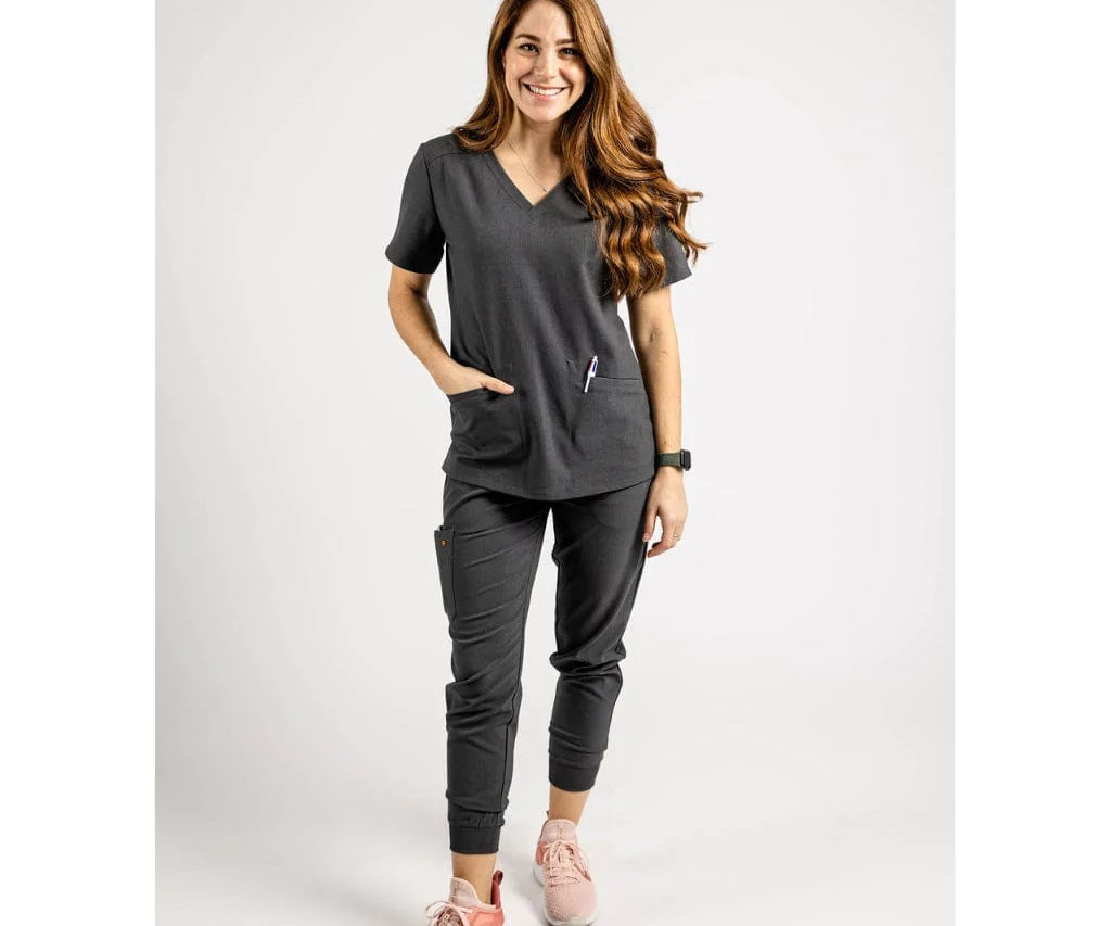 Full body picture of the the Caswell scrub top in charcoal gray.
