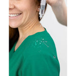 Water repellant detail picture of the the Caswell scrub top in hunter green.