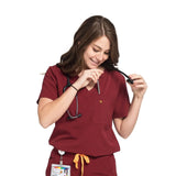 Picture of pocket use of the wilder one-pocket scrub top in burgundy.