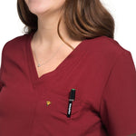 Closeup of pocket use of the wilder one-pocket scrub top in burgundy.