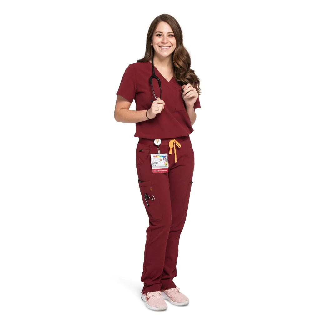 Full body picture of the wilder one-pocket scrub top in burgundy.
