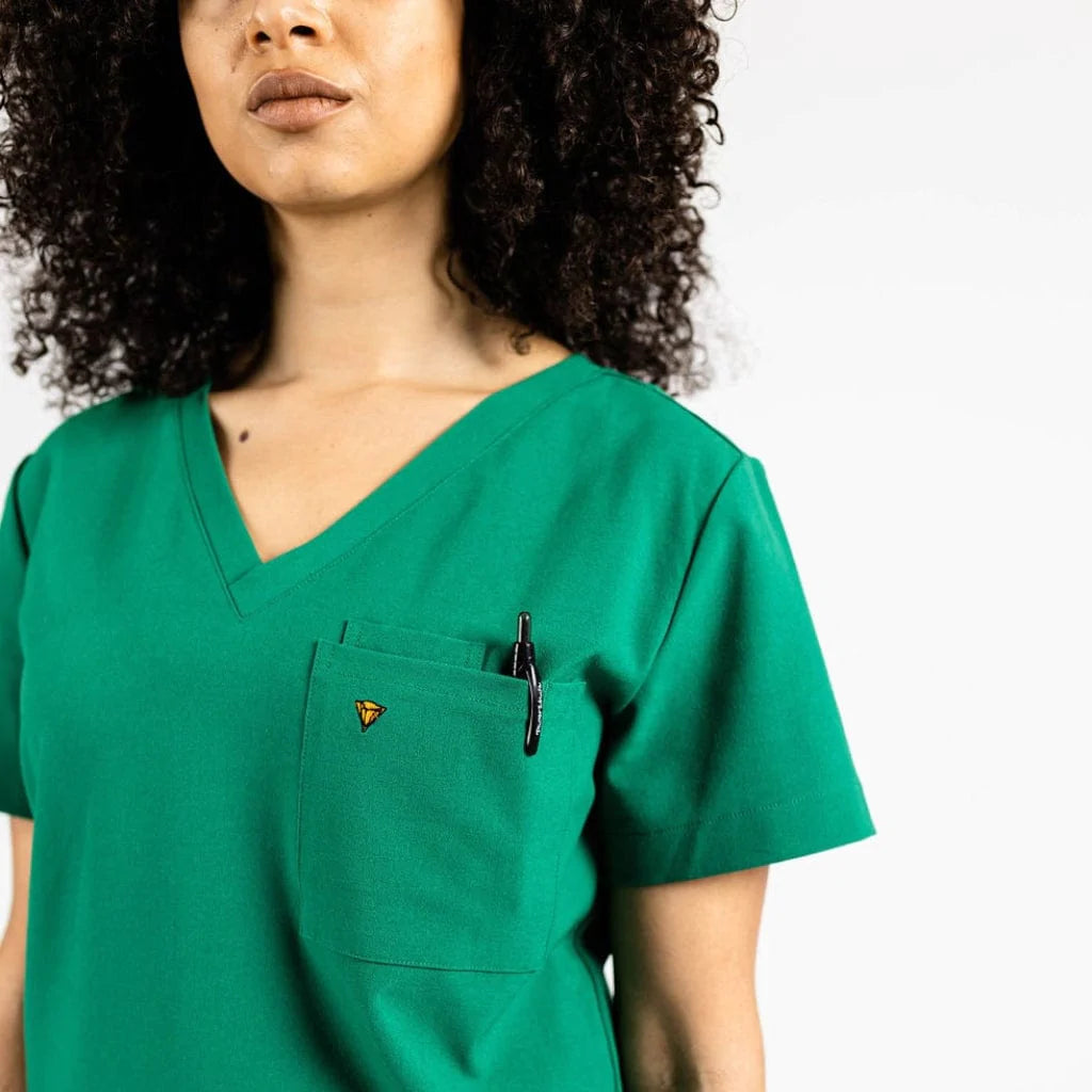 Close up picture of the pocket detail of the wilder one-pocket scrub top in hunter green.